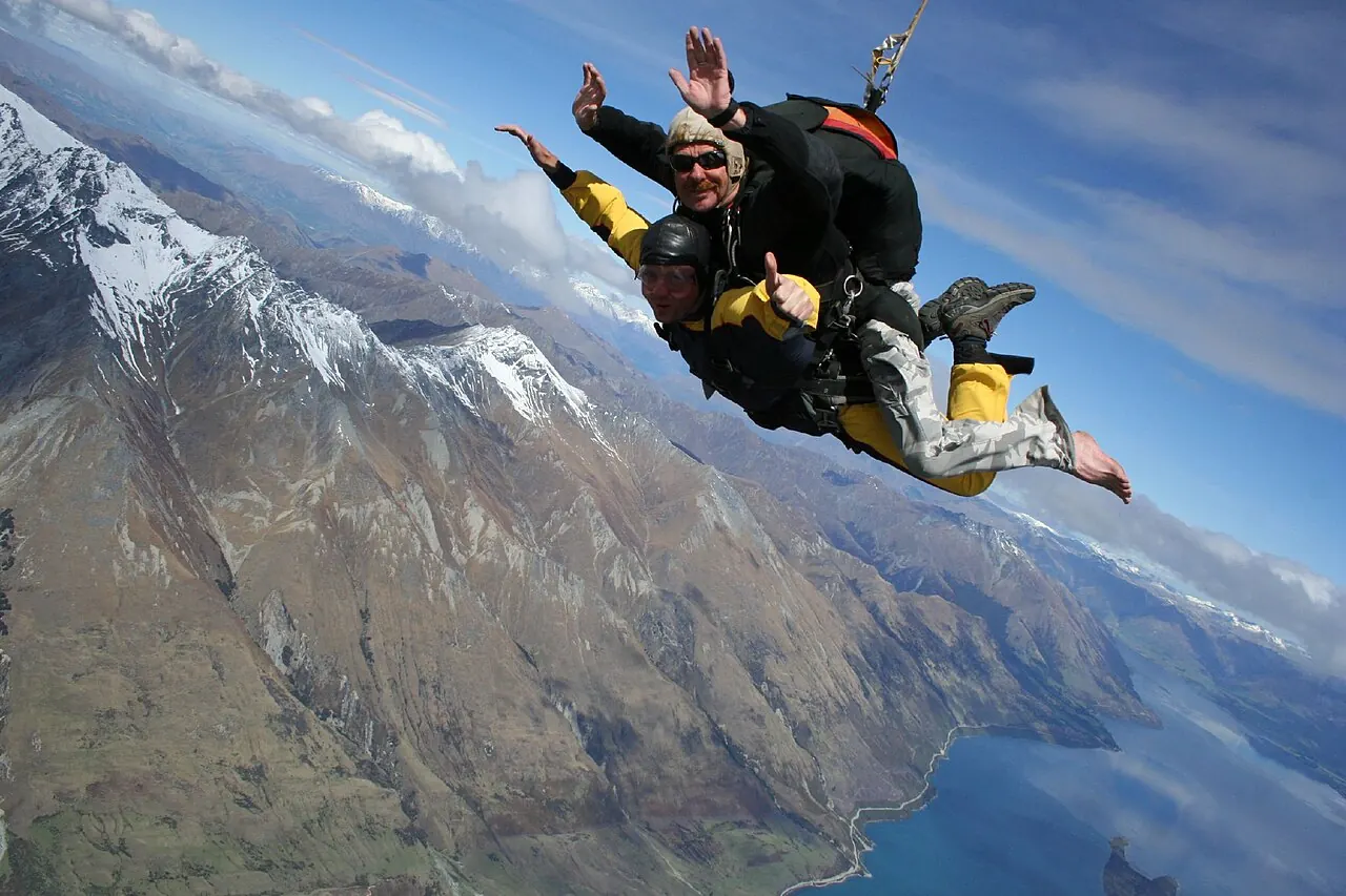 Tandem skydivers in freefall above the mountains near Queenstown