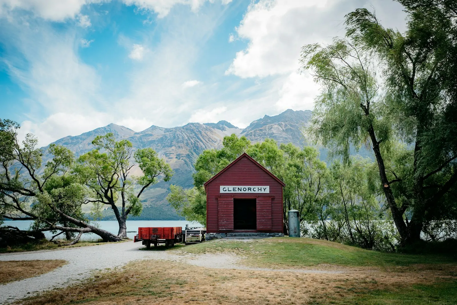The red Glenorchy boatshed on Lake Wakatipu below the mountains