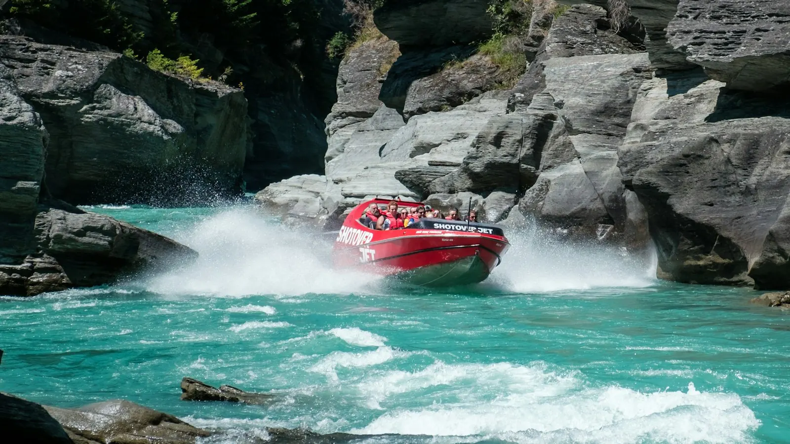 A jet boat speeding through the Shotover River canyon at Arthurs Point